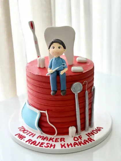 A special cake for the 'Tooth Maker of India'. This dentist-themed cake features a caricature, a giant tooth, and edible dental tools.