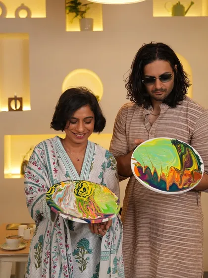Sucharita and Ali showing off their finished fluid art pieces. Each one is a unique swirl of colors, reflecting their creative expression during the session.