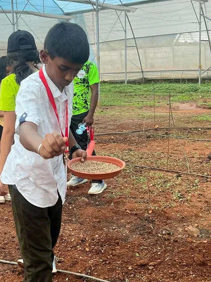 A duplicate of image 68, a boy sowing seeds at summer camp.