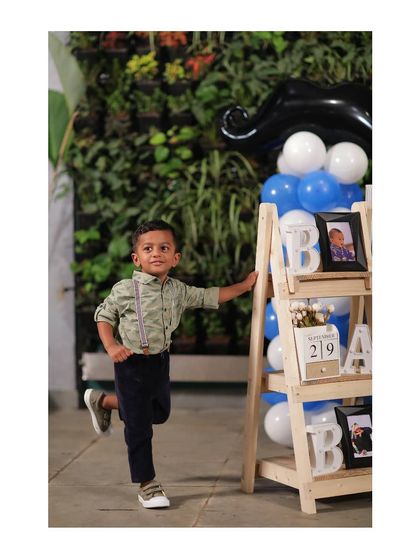 The star of the 'Little Man' party. Little Dhanik looking dapper next to our decorative ladder shelf, which we styled with marquee letters, a personalized photo frame, and a custom date calendar.