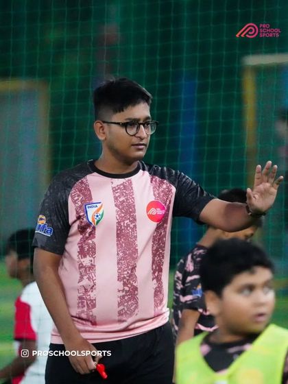 A coach guides his players during a training session, showing his focus and dedication.