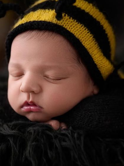 A sweet close-up of our little honey bee, focusing on the baby's adorable pout and the details of the knitted bee hat.
