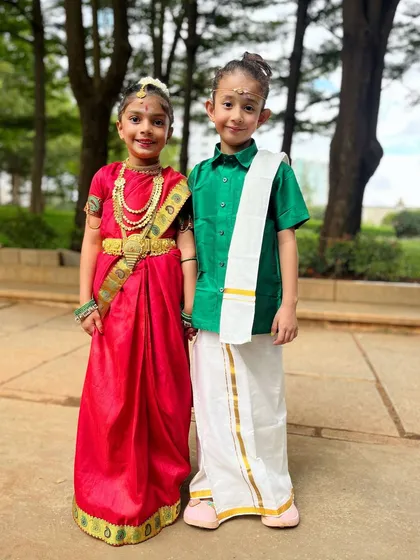 Culture and cuteness combined. These two students proudly wear their traditional attire, representing the next generation of dancers keeping our heritage alive.