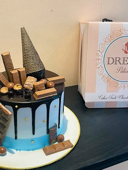 An artistic take on the chocolate overload cake, featuring an inverted cone and a variety of milk and dark chocolates. The blue ombre base adds a stylish touch.