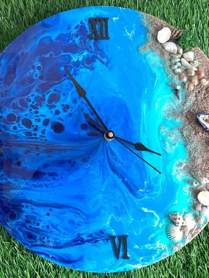 A dramatic ocean clock with deep, swirling blues and a realistic beach with shells and even a tiny boat.