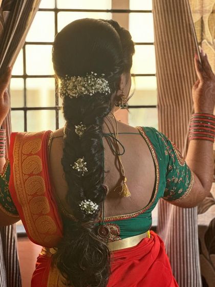 An artistic shot of a bride with her messy fishtail braid, adorned with baby's breath. This style is perfect for a traditional yet modern look.