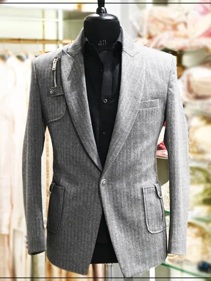Another view of the grey blazer with the zipper detail, showing how it can be worn with a simple black shirt for a clean, contemporary style.