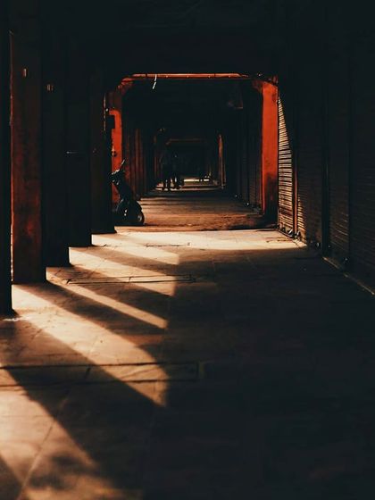 Light and shadow create a dramatic pattern in a dark corridor in Jaipur. This image is about finding beauty in quiet, empty spaces and having the patience to see how light can transform a scene.