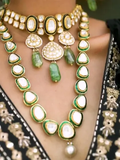 A detailed close-up of the layered polki necklaces. This shot showcases how combining a choker with a longer necklace can create a rich, textured look. The green enamel work adds a beautiful touch of color.