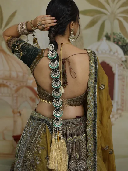 A detailed look at an intricate Punjabi chotla, a traditional bridal braid accessory. I love weaving these beautiful elements into hairstyles, adding a touch of heritage and unmatched elegance to the overall look.