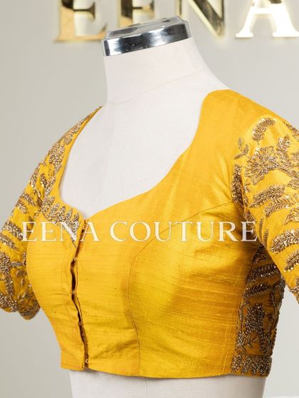 This sunshine yellow raw silk blouse is brought to life with meticulous hand embroidery by my talented artisans. The dense, traditional motifs in antique gold threadwork cover the back and sleeves, creating a piece that radiates warmth and luxury.