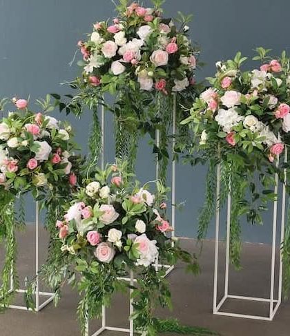 These are elegant floral stands that can be used as centerpieces or to decorate an aisle. I used a mix of white and pink roses with cascading greenery.