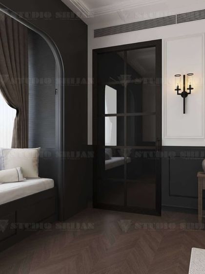 A bedroom with old-world charm, featuring a classic four-poster bed, dark wood flooring, and traditional wall sconces. A cozy window seat is built into an arched nook.