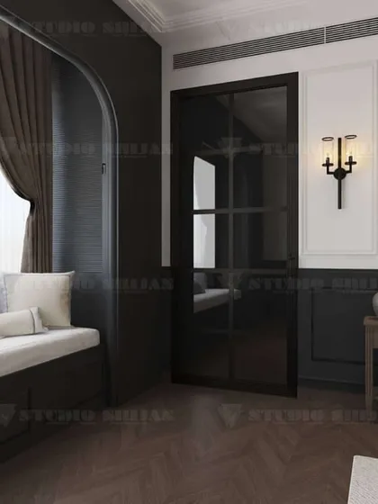 A bedroom with old-world charm, featuring a classic four-poster bed, dark wood flooring, and traditional wall sconces. A cozy window seat is built into an arched nook.