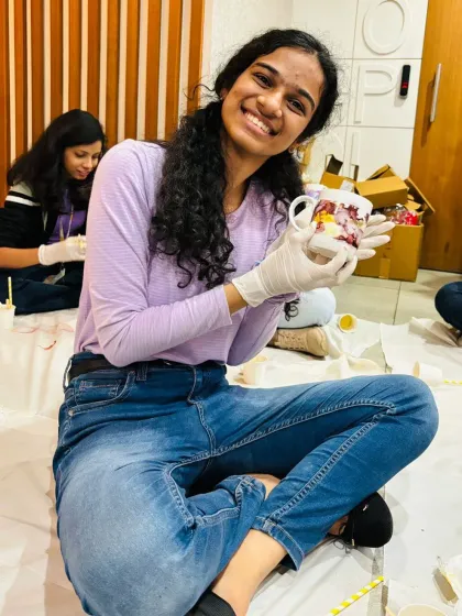 A smiling employee shows off the colorful mug she decorated during a corporate event. These workshops provide a much-needed creative break and a fun, personalized souvenir.