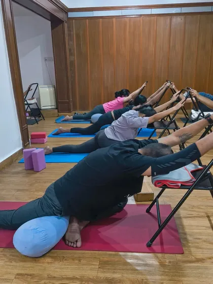 A restful weekend practice. Students use chairs and bolsters to find a supported and deep stretch in pigeon pose, releasing tension from the hips.
