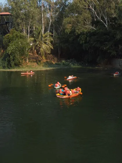 A wide shot of the lake with multiple groups enjoying boating and kayaking under a clear sky.