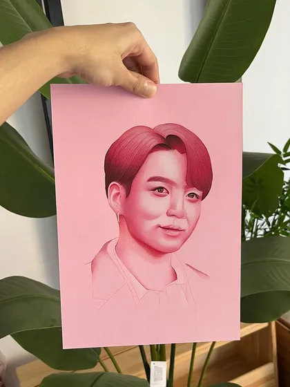 A monochromatic portrait of Jungkook from BTS, created with colored pencils on pink paper. This style uses a limited color palette to create a soft yet striking image that has a very modern feel.