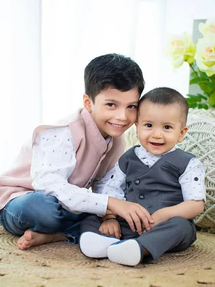 The special bond between brothers. The older brother's gentle smile as he sits with his baby brother is a moment to treasure.