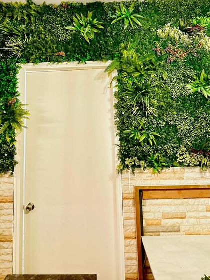 Our green walls can be custom-fit to any space. Here, we framed a doorway with lush artificial foliage, turning a simple entrance into a grand and inviting garden-like portal.