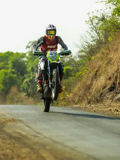 Anish Shetty on his KTM Adventure 390 rally bike, popping a wheelie.