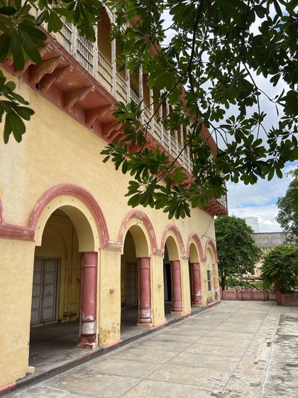 The play of light and foliage on the haveli's arched colonnade, a beautiful moment captured before the restoration work began.