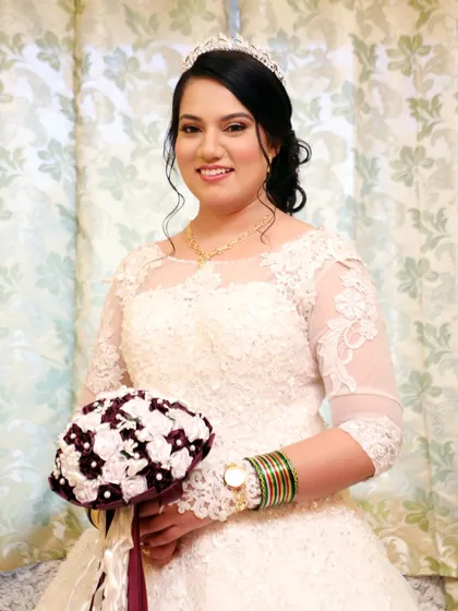 A smiling portrait of the bride, ready for her ceremony. The classic makeup and hair, paired with a beautiful tiara, create a look of timeless bridal elegance.