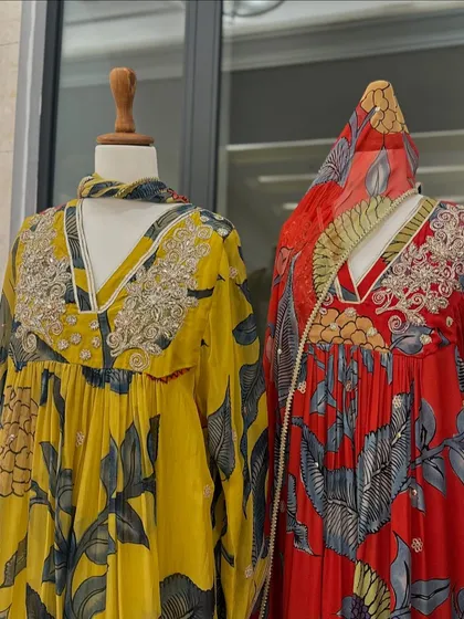 A detailed shot of two floral kurtas, one in yellow and one in red, highlighting the intricate silver gota patti work.