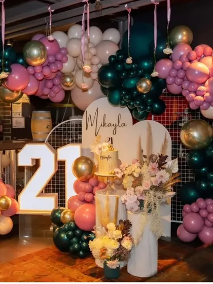 The full view of the 21st birthday decor, showing how the balloons, florals, and lighting come together to transform a bar space into a chic party venue.
