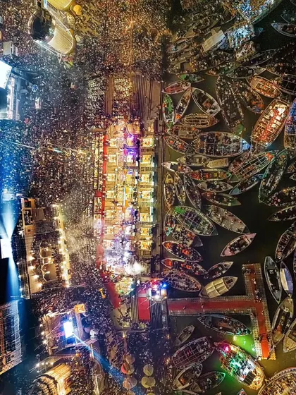 An aerial view of the spectacular Ganga Aarti in Banaras. The ghats light up with devotion as countless boats gather on the holy river, creating a sight you will never forget.
