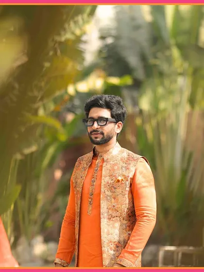 A portrait of our groom, looking dapper in his orange kurta and printed jacket, ready for the Mehendi festivities.