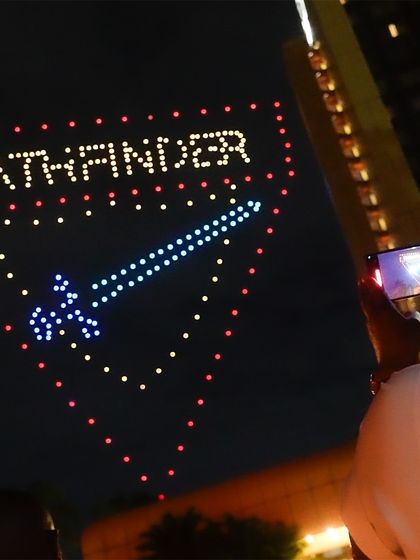 A spectator captures our "Pathfinder" drone formation in Zimbabwe. Our shows are designed to be highly photogenic, encouraging audiences to capture and share the moment.
