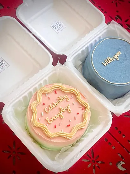 A pair of bento cakes perfect for celebrating together. One has a colorful 'Celebrating everyday' design, and the other a simple 'With you' message.
