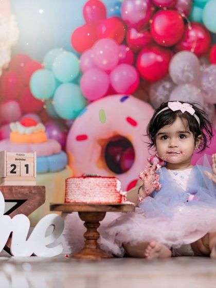 A delightful cake smash session in our candy-themed studio. The pure joy on her face as she digs into the cake is a memory to treasure.