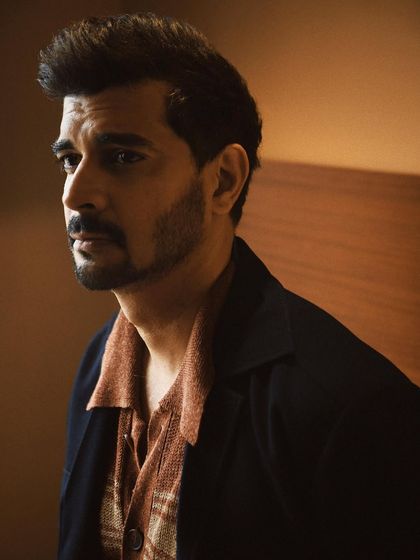 A quiet, contemplative portrait of Tahir Raj Bhasin. The warm, soft lighting and his sideways glance create a cinematic and introspective mood.