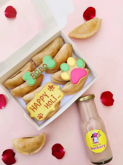 My Holi celebration box is always a big hit. It comes with freshly baked, dog-friendly gujiyas, personalised Holi biscuits, and a bottle of my special 'doggo safe thandai' for a truly festive treat.