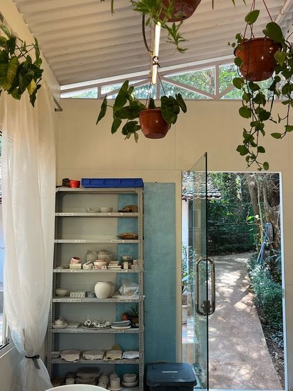 Glimpses of the studio, with shelves of student work waiting to be fired and the green garden just outside the door.