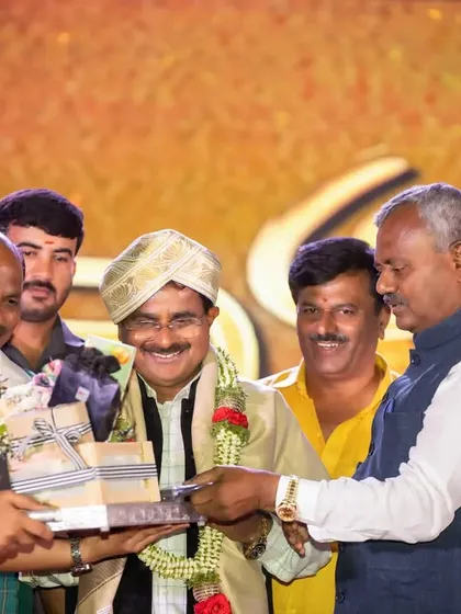 A moment of presentation and felicitation on stage. We focus on the details, from the gift being presented to the expressions of the people involved.