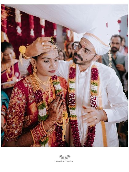 A beautifully composed shot of the groom placing the sacred mark on the bride's forehead, symbolizing their union.
