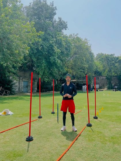 This is the setup for a personal coaching session. The poles and cones are not random, they are placed specifically to guide the bowler's run-up, foot landing, and follow-through, ensuring a perfect action.