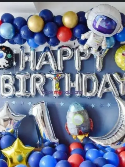 A simple yet impactful space-themed birthday balloon setup. This wall decoration uses blue, red, and gold balloons with large silver foil letters and astronaut-themed accents.