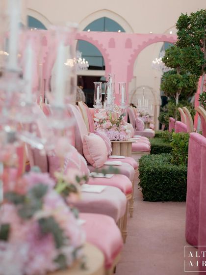 The guest seating for the 'Echoes of Pink' ceremony in Doha. The rows of pink chairs and crystal candelabras created an atmosphere that intimately reflected the couple's romantic story.