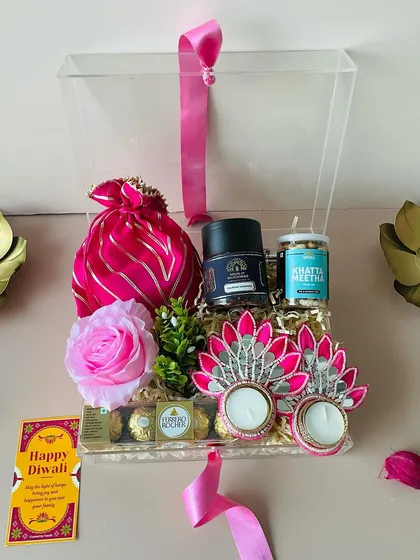 For a modern and chic look, I offer these exquisite acrylic boxes. This one is filled with Ferrero Rocher, snacks, and beautiful pink T-light holders.