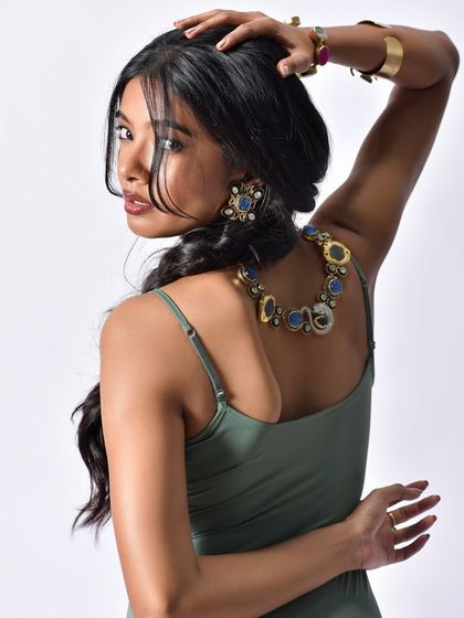 A great way to showcase a necklace and earrings from the back. The over-the-shoulder pose is classic and elegant, revealing the full design of the jewelry set.
