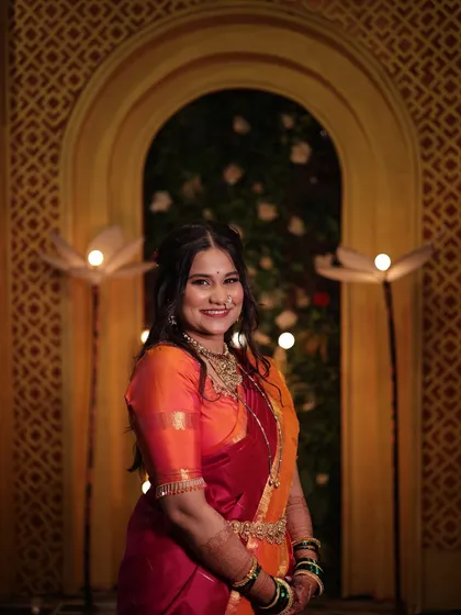 A beautiful portrait of the client ready for her puja. The look is completed with traditional gold jewelry and a radiant makeup finish.