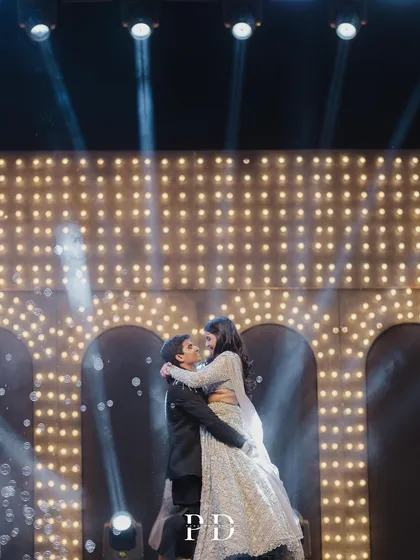 A romantic lift during the couple's dance, with spotlights creating a beautiful silhouette against the marquee-light backdrop.