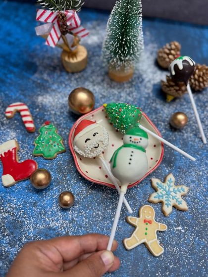 A festive flatlay of my Christmas collection, including Santa and snowman cake pops alongside an assortment of decorated sugar cookies.