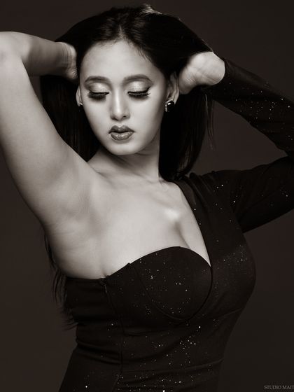 A closer black and white shot of the model in the same dress, with her eyes closed, creating a soft and glamorous mood.