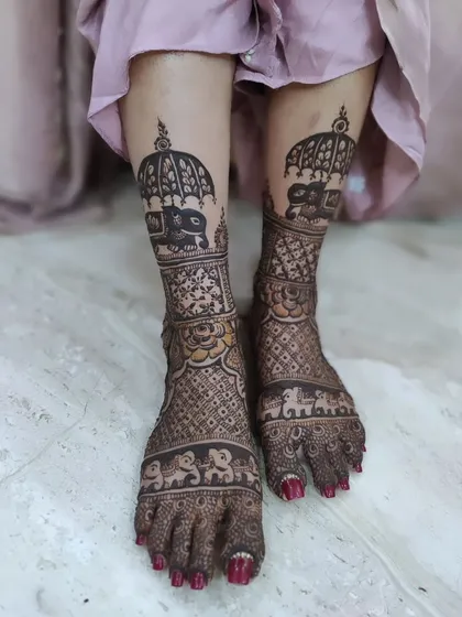 This bridal leg mehendi features bands of tiny elephants and a large, regal elephant with an umbrella on the shin. A design fit for a queen!