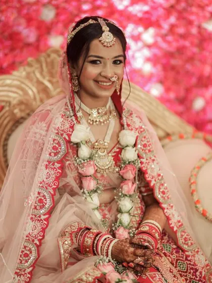 A happy bride on her wedding day, with a classic bun that perfectly complements her traditional jewelry and attire.